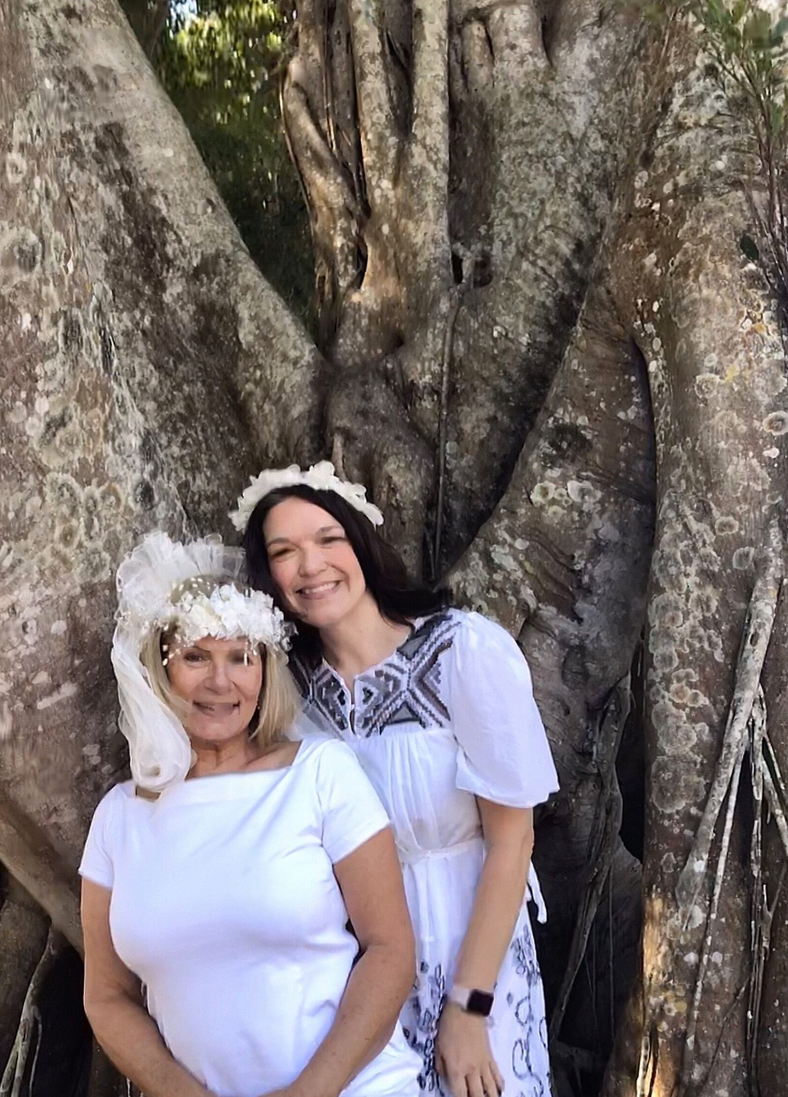 Brides Karen Cooper, left, and Dana Foglesong pose for a wedding photo in front of their "groom," an ancient ficus tree they've vowed to cherish and protect.