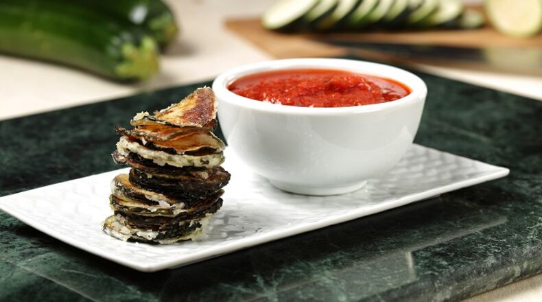 Fresh slices of zucchini, coated with a light dusting of potato starch, transform into crispy chips when deep fried. Marinara sauce makes a zesty dip. (Abel Uribe/Chicago Tribune/TNS)