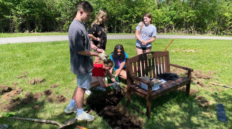 Close friends of Lily Clingner, a 17-year-old Fairborn High School student killed in a crash in December 2022, planted lilies at the bench in Community Park in her honor. CONTRIBUTED