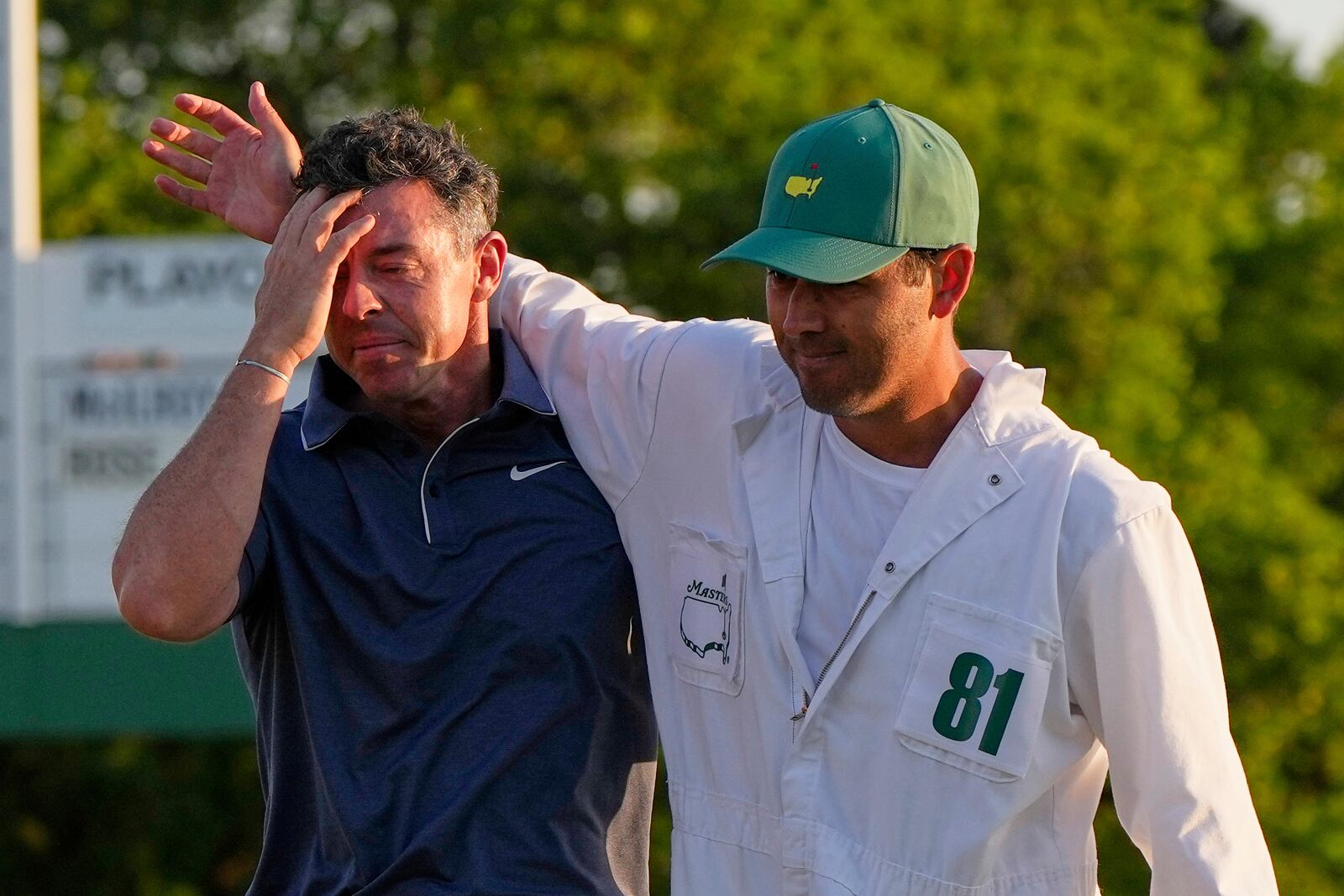 Rory McIlroy, of Northern Ireland, left, is embraced by caddie Harry Diamond after winning in a playoff against Justin Rose, of England, after the final round the Masters golf tournament, Sunday, April 13, 2025, in Augusta, Ga. (AP Photo/David J. Phillip)