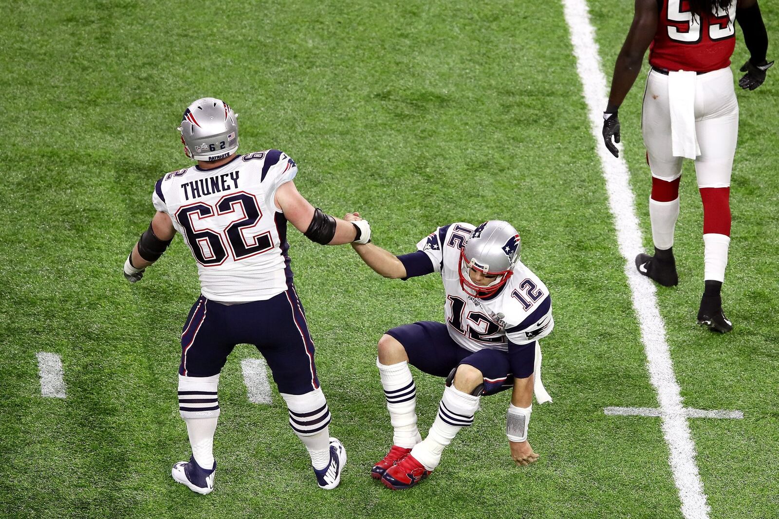 HOUSTON, TX - FEBRUARY 05: Joe Thuney #62 of the New England Patriots helps up Tom Brady #12 during the second quarter of Super Bowl 51 against the Atlanta Falcons at NRG Stadium on February 5, 2017 in Houston, Texas. (Photo by Ezra Shaw/Getty Images)