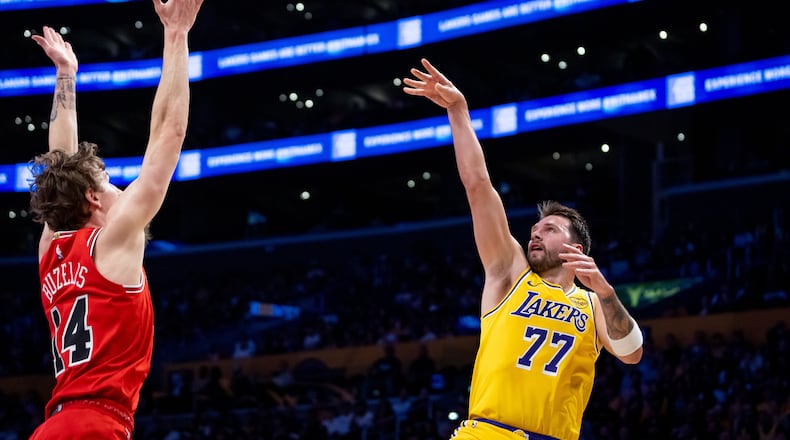 Los Angeles Lakers guard Luka Doncic (77) shoots against Chicago Bulls forward Matas Buzelis (14) during the first half of an NBA basketball game against the Chicago Bulls, Thursday, March 12, 2026, in Los Angeles. (AP Photo/Ethan Swope)