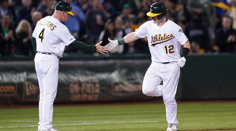 OAKLAND, CALIFORNIA - SEPTEMBER 04: Sean Murphy #12 of the Oakland Athletics is congratulated by third base coach Matt Williams #4 after Murphy hit a solo home run against the Los Angeles Angels of Anaheim in the bottom of the fifth inning at Ring Central Coliseum on September 04, 2019 in Oakland, California. The home run was Murphy's first career hit. (Photo by Thearon W. Henderson/Getty Images)
