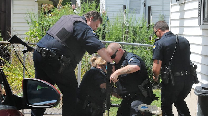 Dayton police caught a man who initially barricaded himself in a house and then tried to jump a fence to escape capture on Tuesday afternoon. MARSHALL GORBY\STAFF