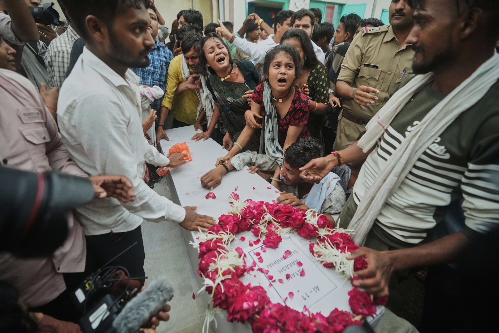 Family members and relatives of Akash Patni, victim of the Air India plane crash, grieve as his body arrives for funeral in Ahmedabad, India, Tuesday, June 17, 2025. (AP Photo/Ajit Solanki)