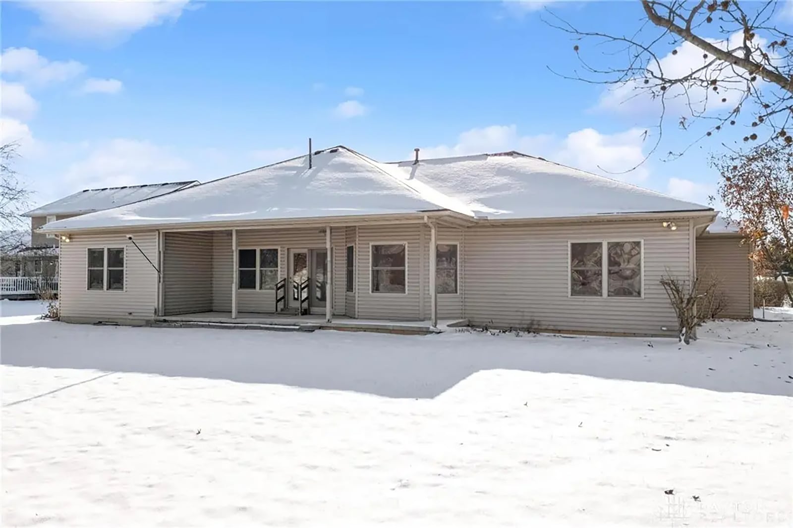 the back of the home features a covered concrete patio with steps down to the yard. CONTRIBUTED