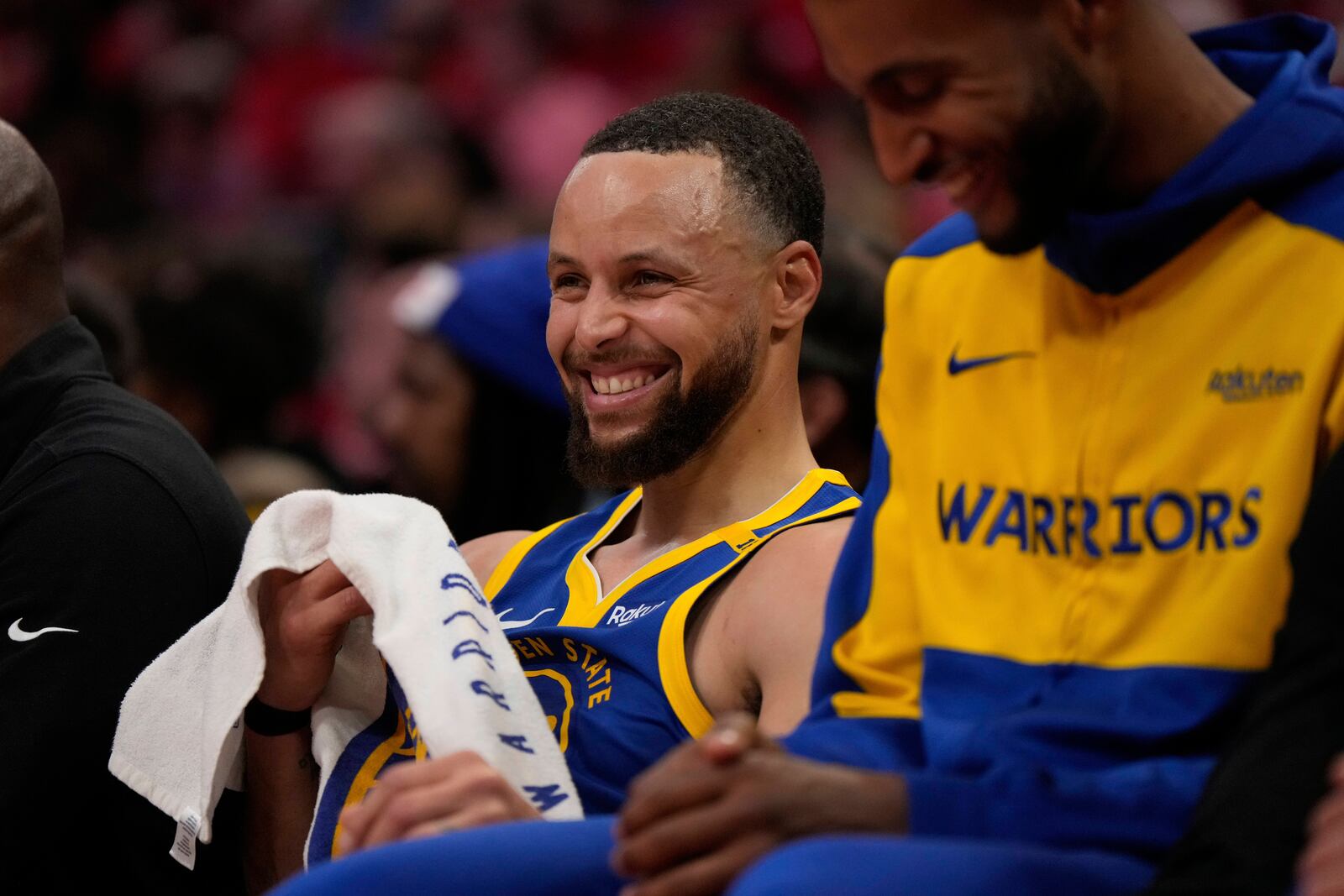 Golden State Warriors guard Stephen Curry (30) smiles from the bench during the second half of Game 1 of an NBA basketball first-round playoff series against the Houston Rockets in Houston, Sunday, April 20, 2025. (AP Photo/Ashley Landis)
