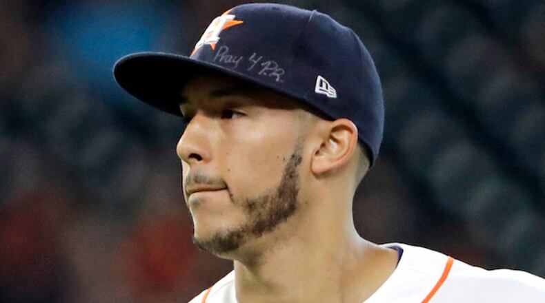 This is a Sept. 23, 2017, file photo showing Houston Astros shortstop Carlos Correa wears a message on his cap for those affected by the Hurricane in Puerto Rico during the second inning of a baseball game. (AP Photo/David J. Phillip, File)