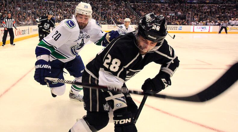 The Vancouver Canucks' Chris Higgins, left, chases the Los Angeles Kings' Jarrett Stoll (28) along the boards at Staples Center in Los Angeles, California, on Saturday, March 23, 2013. The Canucks won, 1-0. (Brian van der Brug/Los Angeles Times/MCT)
