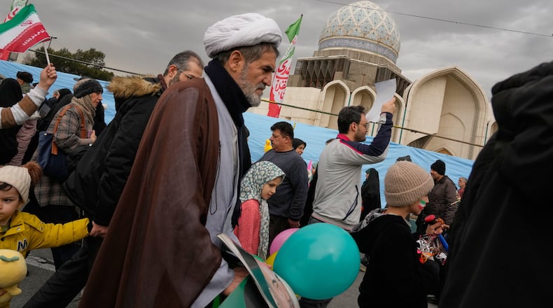 A cleric and other people attend an annual rally marking 1979 Islamic Revolution in Tehran, Iran, Wednesday, Feb. 11, 2026. (AP Photo/Vahid Salemi)