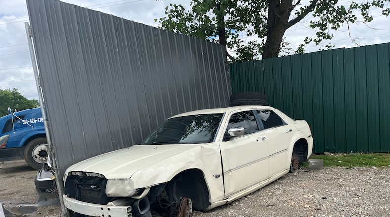 A junked car outside of a fence surrounding a property at 1801 Valley St., in Old North Dayton. The property for years was a junk yard. CORNELIUS FROLIK / STAFF