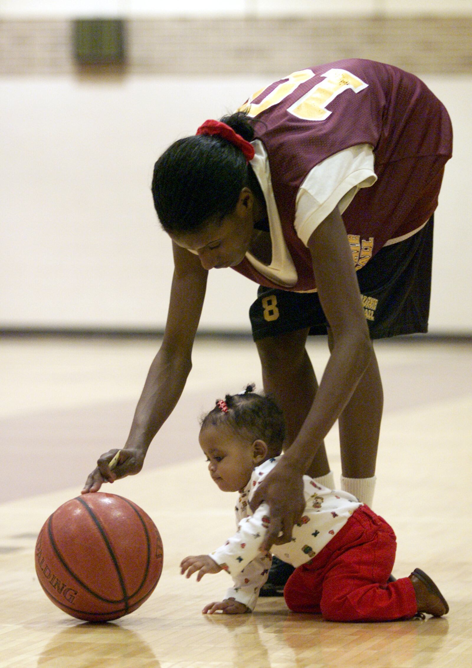 During a break in basketball practice, Chantel White plays with her daughter Shadayah during the 1999 season. Shadayah was a fixture with the women's basketball team at Central State University. Lisa Powell/DDN FILE