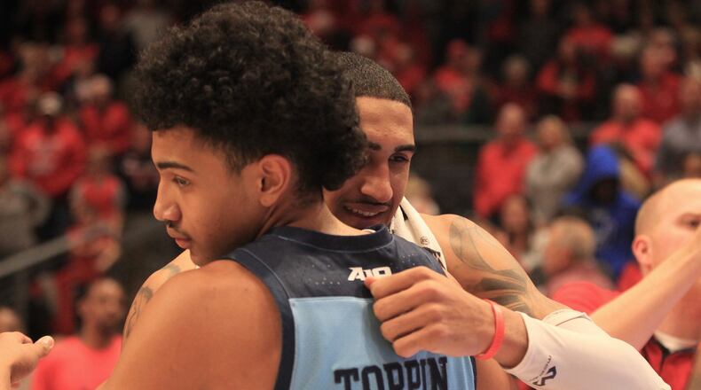 Dayton’s Obi Toppin hugs his younger brother Jacob after the game on Tuesday, Feb. 11, 2020, at UD Arena. David Jablonski/Staff