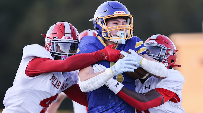 Lehman Catholic senior receiver Evan O'Leary runs while trying to fight off Northridge's Tre'von Rowe (left) and Sulaiman Muhhamed (right) during a Three Rivers Conference game on Thursday, Sept. 11 at Sidney Memorial Stadium. The Cavaliers pulled away in the second half to a 34-16 win. BRYANT BILLING / STAFF