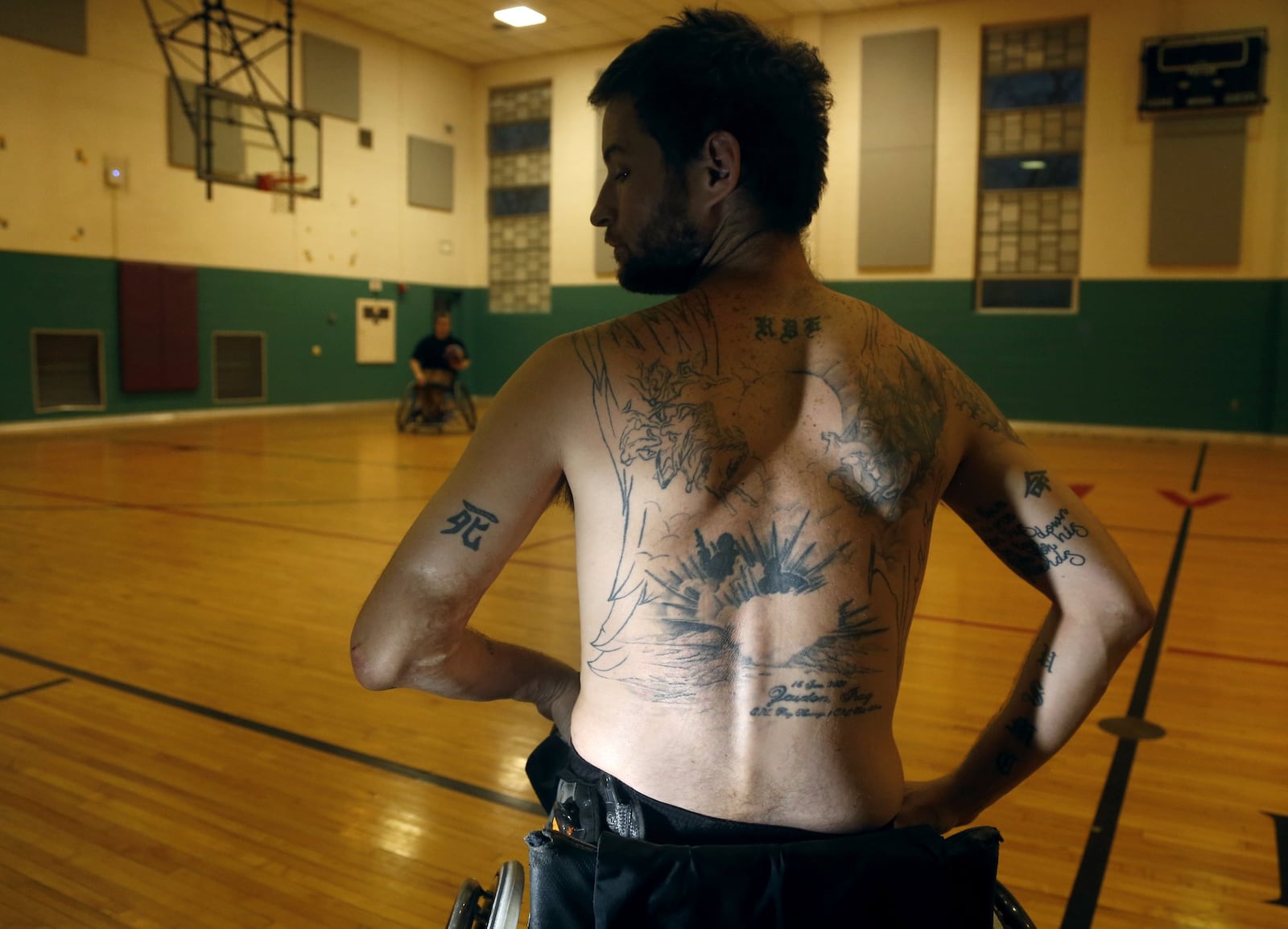 Ray Hennagir of Fairborn lost both legs and the fingers on his right hand when he stepped on an IED during his third tour of duty in Iraq as a Marine combat engineer. A tattoo on his back, not complete yet, will depict the explosion that he and a fellow Marine were caught up in. LISA POWELL / STAFF