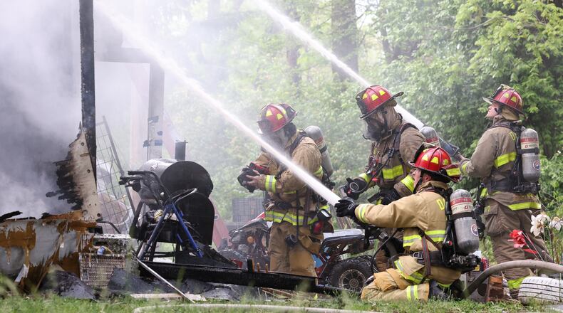 Dayton firefighters work to put out a blaze at 3713 Fairbanks Avenue on Tuesday evening. One dog died in the fire, which district fire chief Andrew Wiley said appears suspicious. The fire remains under investigation. BRYANT BILLING / STAFF