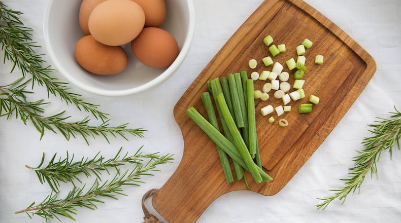 Some of the ingredients that go into a breakfast strata, made with eggs, cheese, bread, green onions, rosemary and other ingredients. Stratas make great use of leftover bread and other items. (Ellen M. Banner/The Seattle Times/TNS)