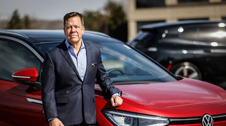 Jim Evans is the owner of Evans Dealer Group including Evans Volkswagen on Poe Avenue. Evans is standing next to an ID.4 Volkswagen electric vehicle. JIM NOELKER/STAFF