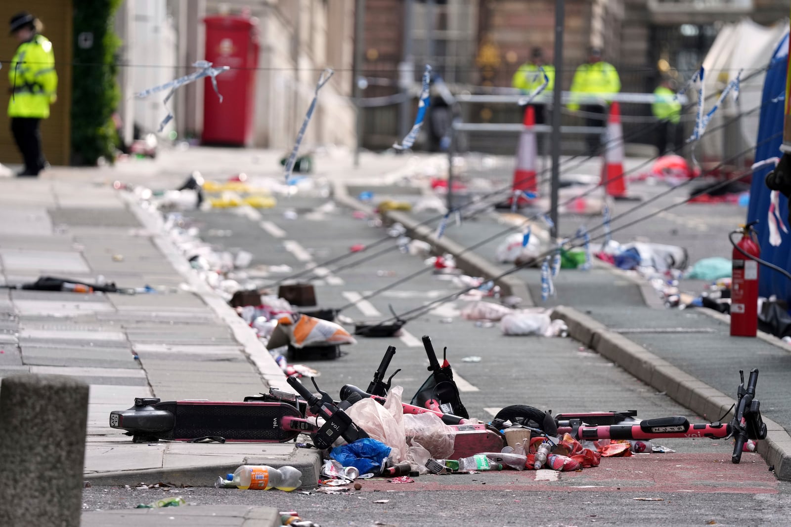 Scooters lie on the site where a 53-year-old British man plowed a minivan into a crowd of Liverpool soccer fans who were celebrating the city's Premier League championship Monday, injuring more than 45 people in Liverpool, England, Tuesday, May 27, 2025.(AP Photo/Jon Super)