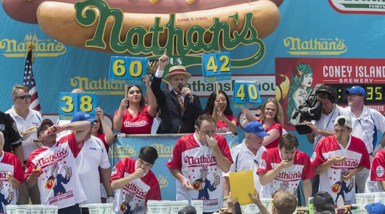 Reigning champion Joey Chestnut eats two hot dogs at a time during the men's competition of the Nathan's Famous Fourth of July hot dog eating contest, Wednesday, July 4, 2018, in New York's Coney Island. The defending champion broke his own world record by eating 74 hot dogs in 10 minutes.