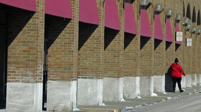 A woman walks along the business in the Park Plaza during a recent sunny day. BILL LACKEY/STAFF
