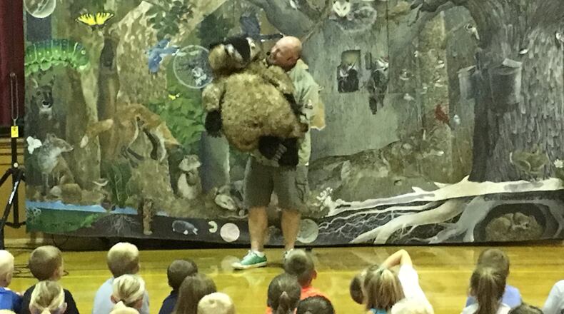 Chris Rowlands is pictured entertaining students in New Bremen. In addition to creating whimsical puppets for his shows, he also designs backdrops. SUBMITTED
