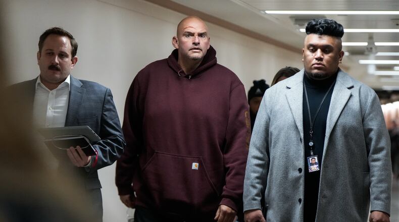 Injuries from a fall are seen on the face of Sen. John Fetterman, D-Pa., second from left, as he walks through a hallway on Capitol Hill, Wednesday, Nov. 19, 2025, in Washington. (AP Photo/Julia Demaree Nikhinson)