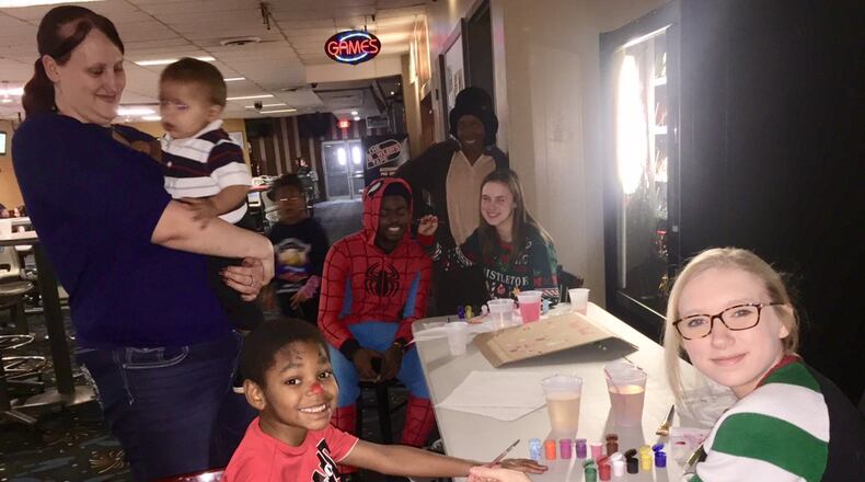 Volunteers do face painting for party guests at Jingle Bell Bowl. DEBBIE JUNIEWICZ / CONTRIBUTED