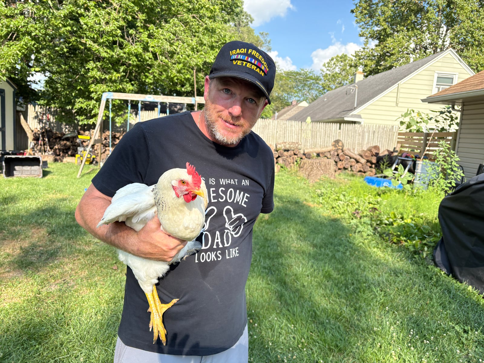 Todd Combs holds one of his pet chickens  Sunday, July 13, 2025, in the backyard of his Kenosha Road home in Kettering. JEN BALDUF/STAFF
