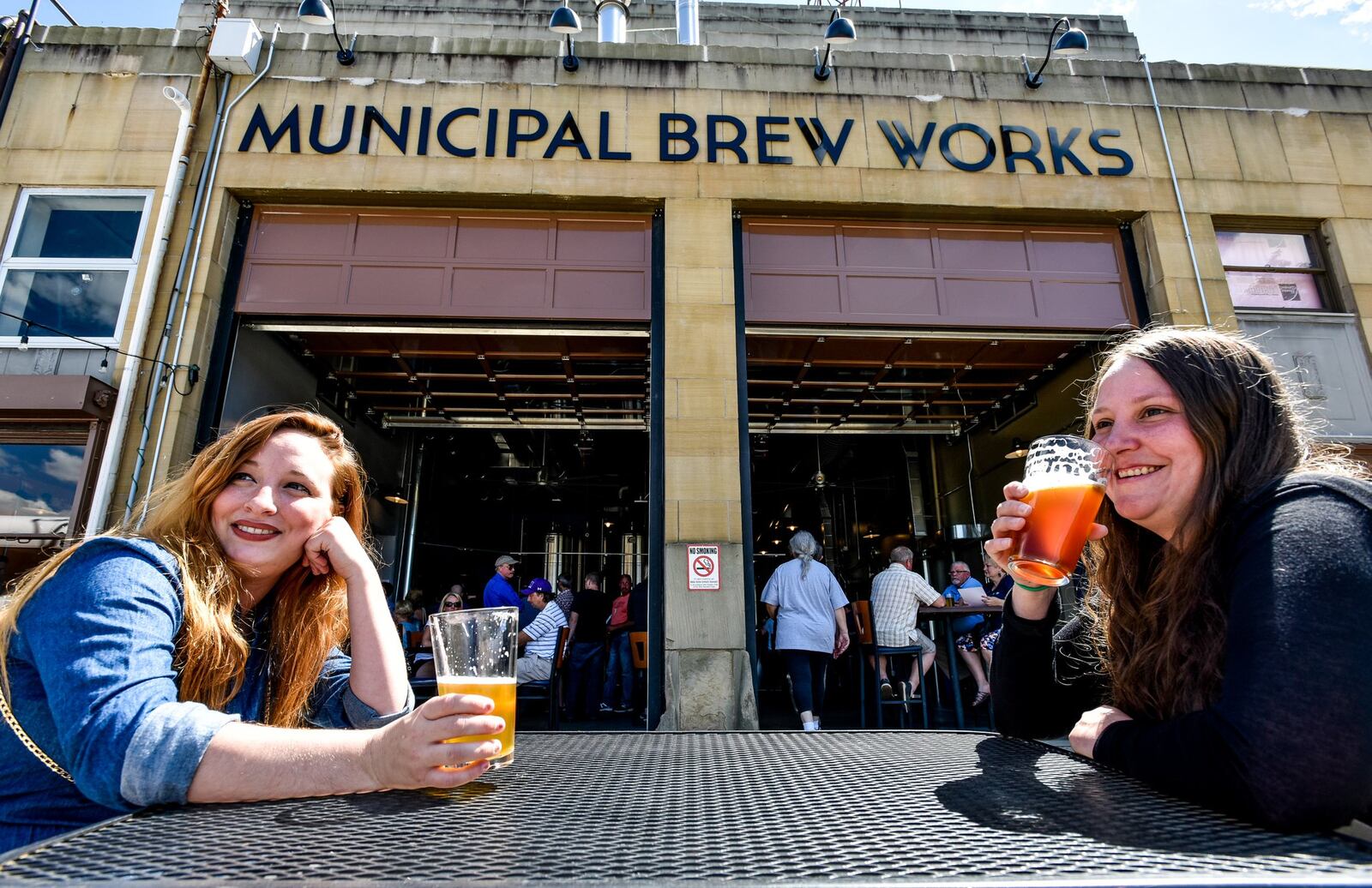 Kyla Oglesbee, left, and Sarah Shepherd try out the beers during the grand opening of Municipal Brew Works in 2016.  