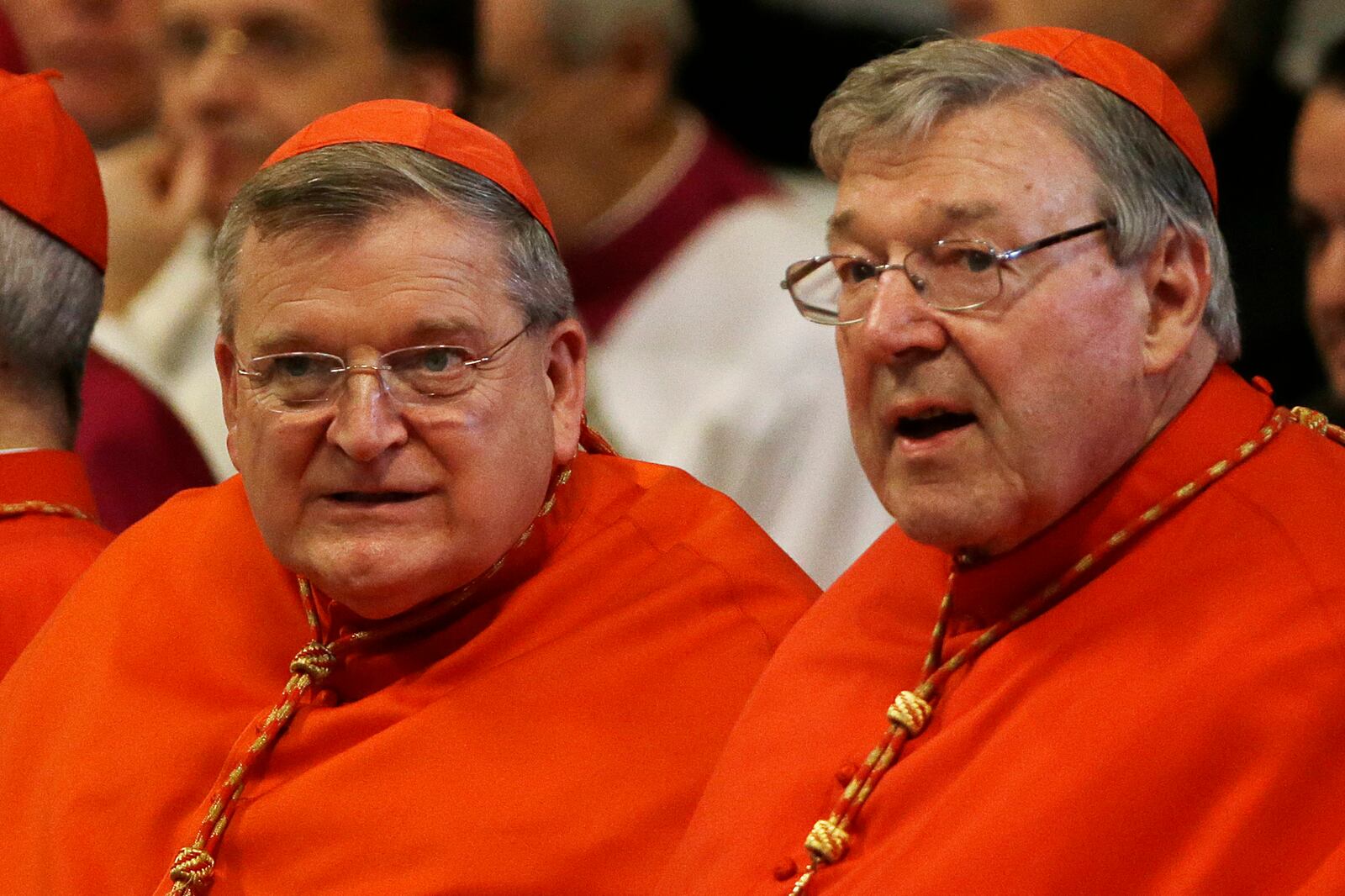 FILE - Cardinal Raymond Leo Burke, left, and Cardinal George Pell wait for the arrival of Pope Francis on the occasion of a Mass where the pontiff bestowed the Pallium, a woolen shawl symbolizing their bond to the pope, to new Metropolitan Archbishops, in St. Peter's Basilica at the Vatican, Monday June 29, 2015. (AP Photo/Gregorio Borgia, file)