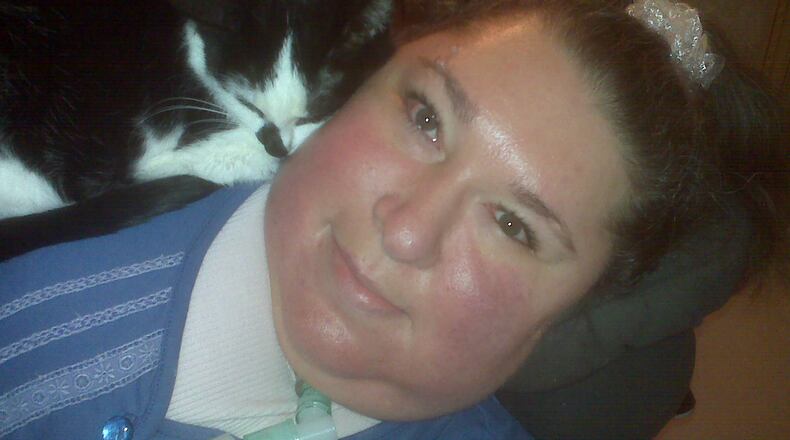 Maria Matzik uses a reclining wheelchair after a spinal fusion surgery left her unable to sit upright. She has also been on a ventilator to help her breathe for many years. She is shown with one of her beloved cats, "Lil Wee." CONTRIBUTED