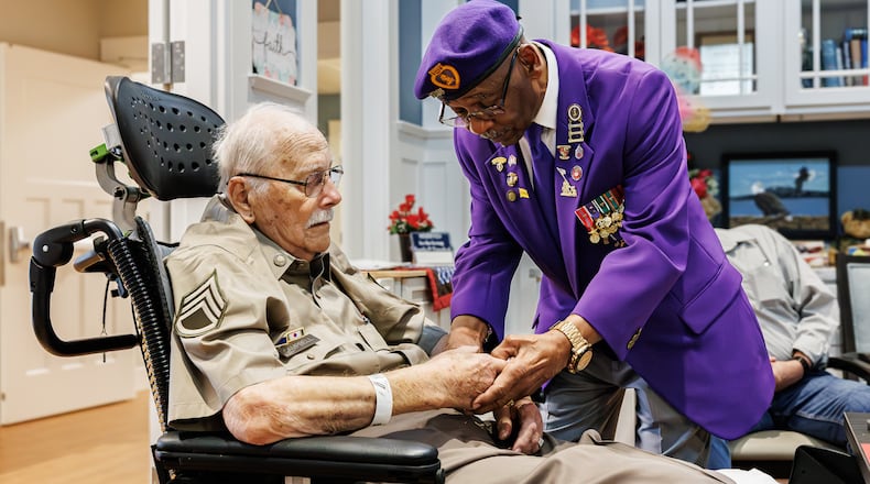 Jerry Ferris, the Ohio Commander of the Military Order of the Purple Heart, presents Korean War veteran Leroy Campbell, 93, with a Purple Heart coin during a ceremony Tuesday, April 15, 2025, at Victory Ridge hospice on Dayton VA Medical Center campus. BRYANT BILLING / STAFF