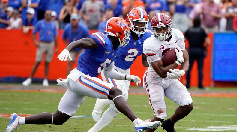 Alabama running back Jase McClellan, right, gains yardage as he tries to get past Florida cornerback Kaiir Elam (5) and linebacker Amari Burney (2) during the first half of an NCAA college football game, Saturday, Sept. 18, 2021, in Gainesville, Fla. (AP Photo/John Raoux)