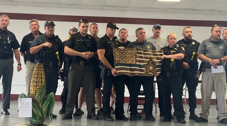 Clark County Sheriff's Office employees stand with a wood carving created to honor Deputy Matt Yates Thursday evening. Photo provided by Dean Blair.