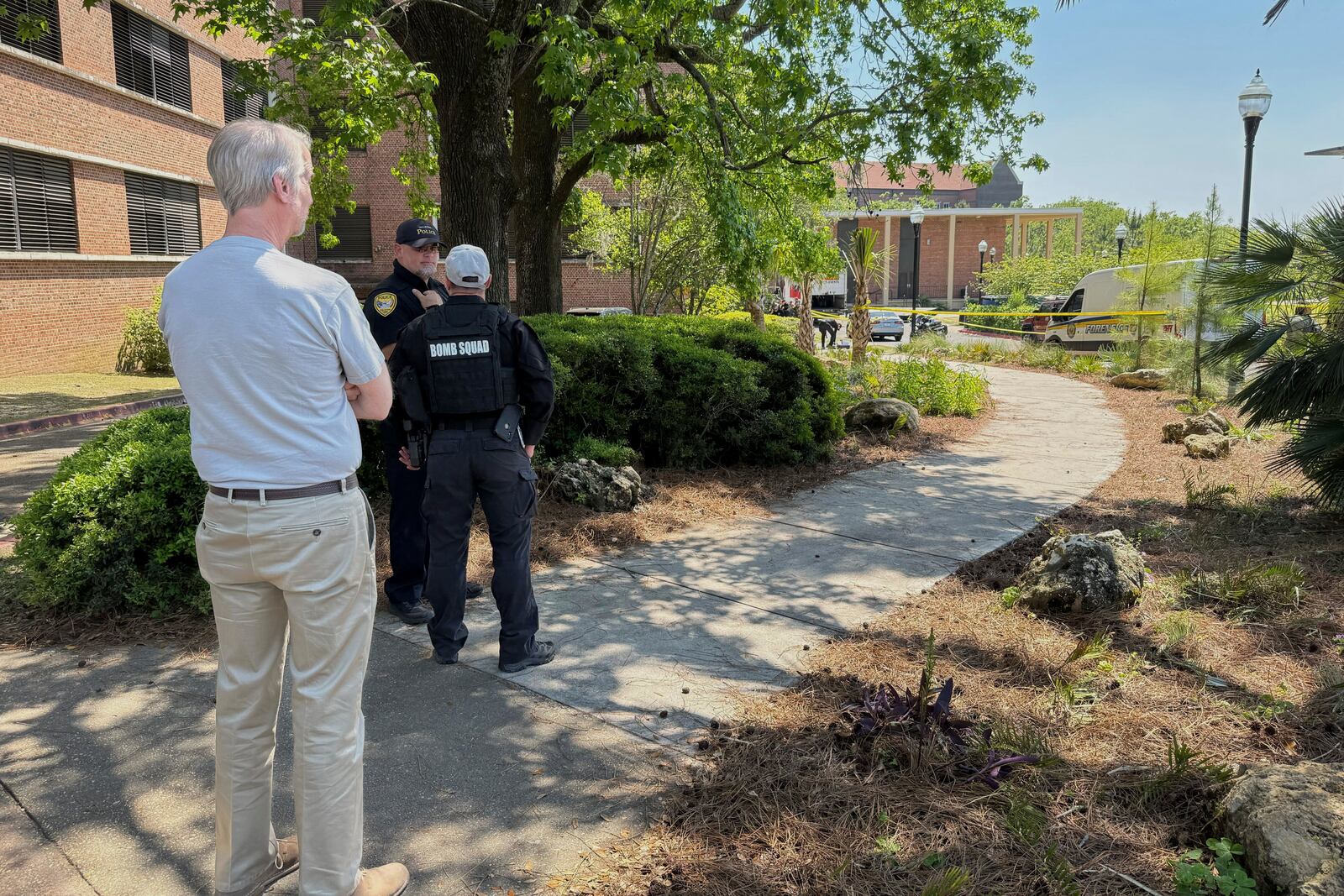 Dozens of patrol vehicles, including a forensics van, are stationed outside of Florida State University’s student union building, the scene of a shooting, Thursday, April 17, 2025, in Tallahassee, Fla. (AP Photo/Kate Payne)