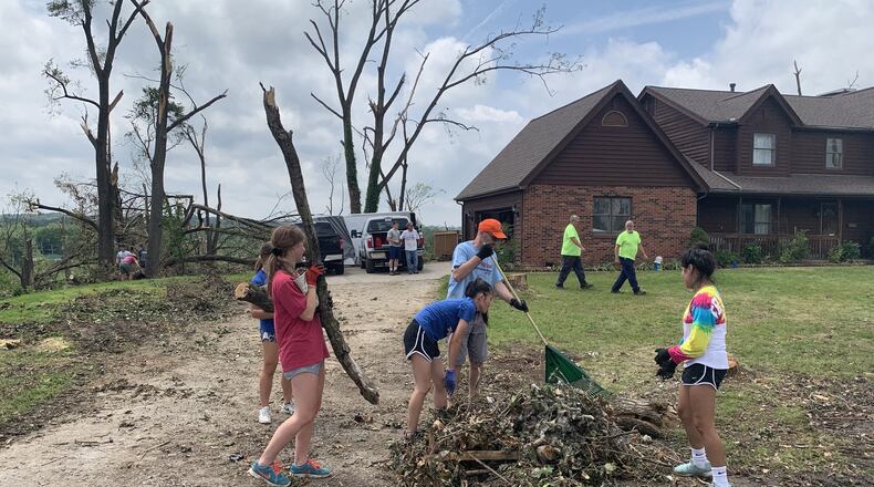 Carroll students clean up tornado debris on Wednesday in Dayton. NOLAN SIMMONS / STAFF