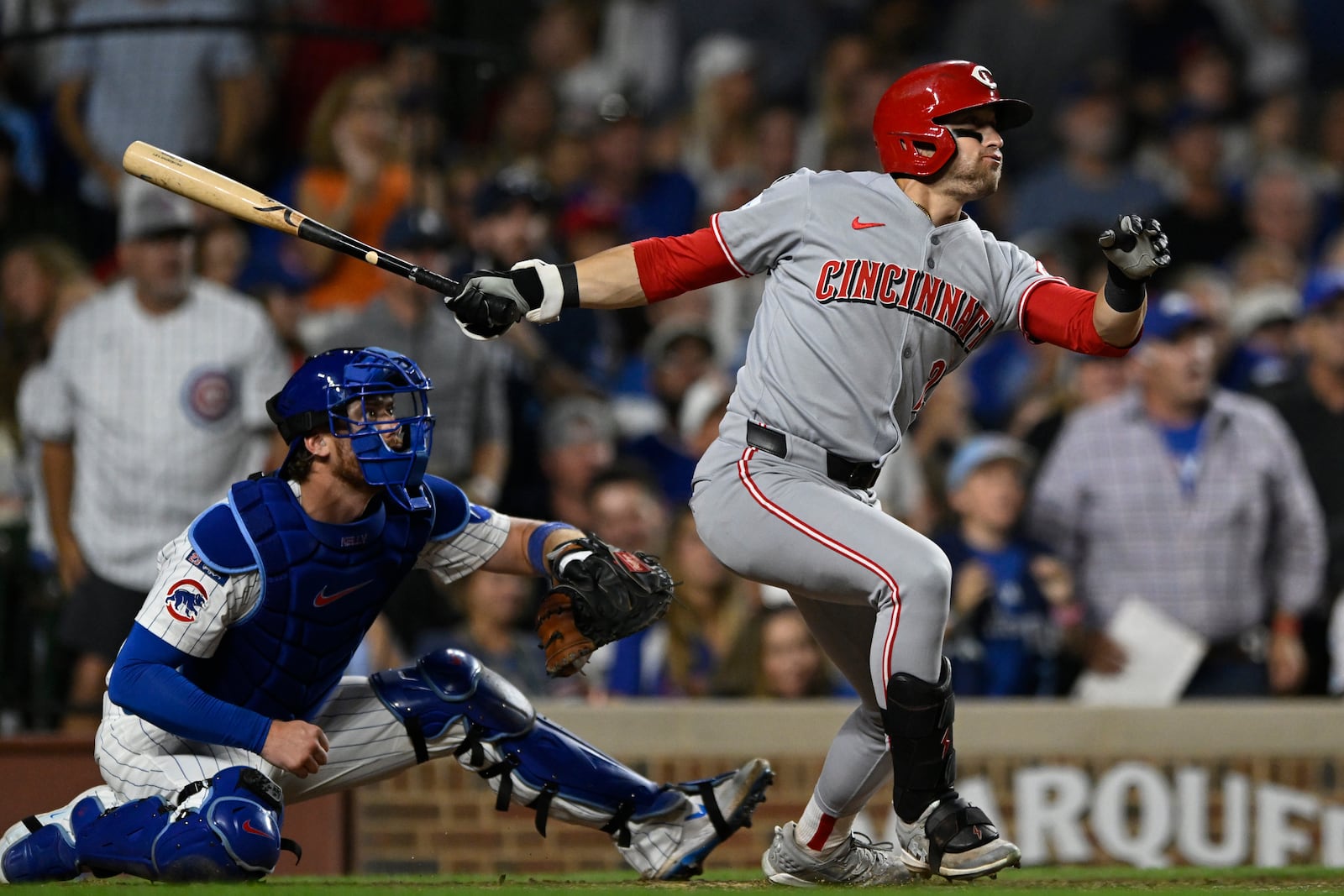 Cincinnati Reds' TJ Friedl, right, watches his RBI single during the seventh inning of a baseball game against the Chicago Cubs, Monday, Aug. 4, 2025, in Chicago. (AP Photo/Paul Beaty)