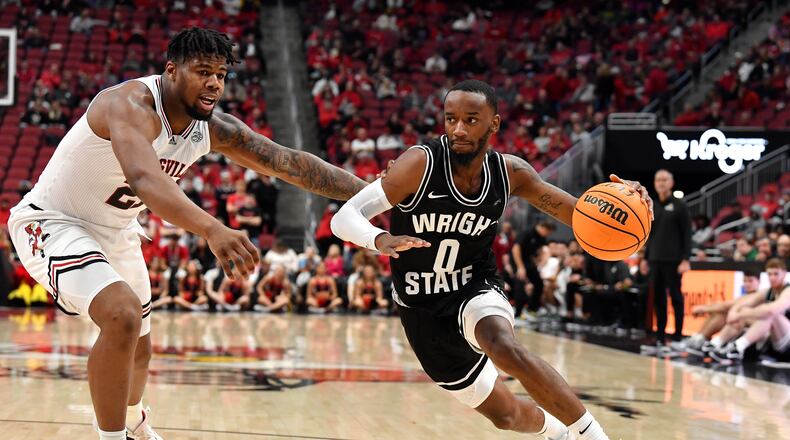 Wright State guard Amari Davis (0) drives past Louisville forward Sydney Curry (21) during the first half of an NCAA college basketball game in Louisville, Ky., Saturday, Nov. 12, 2022. (AP Photo/Timothy D. Easley)