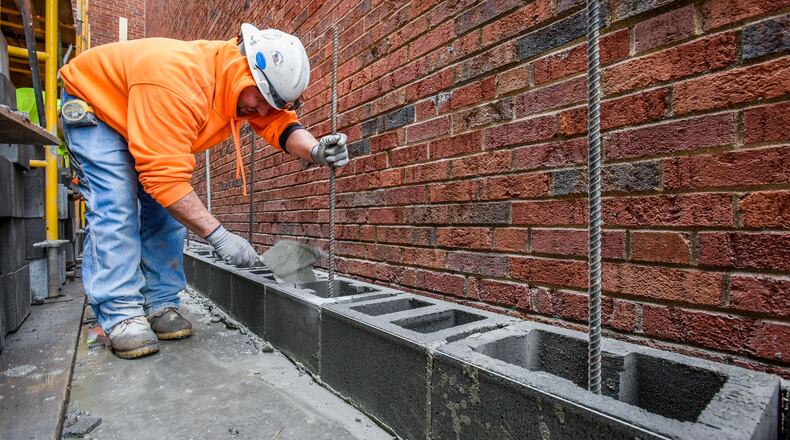 Junior Ard with Conger Construction lays block on site of the renovation and addition of Middletown High School and the new middle school Tuesday, Feb. 7 in Middletown. NICK GRAHAM/STAFF