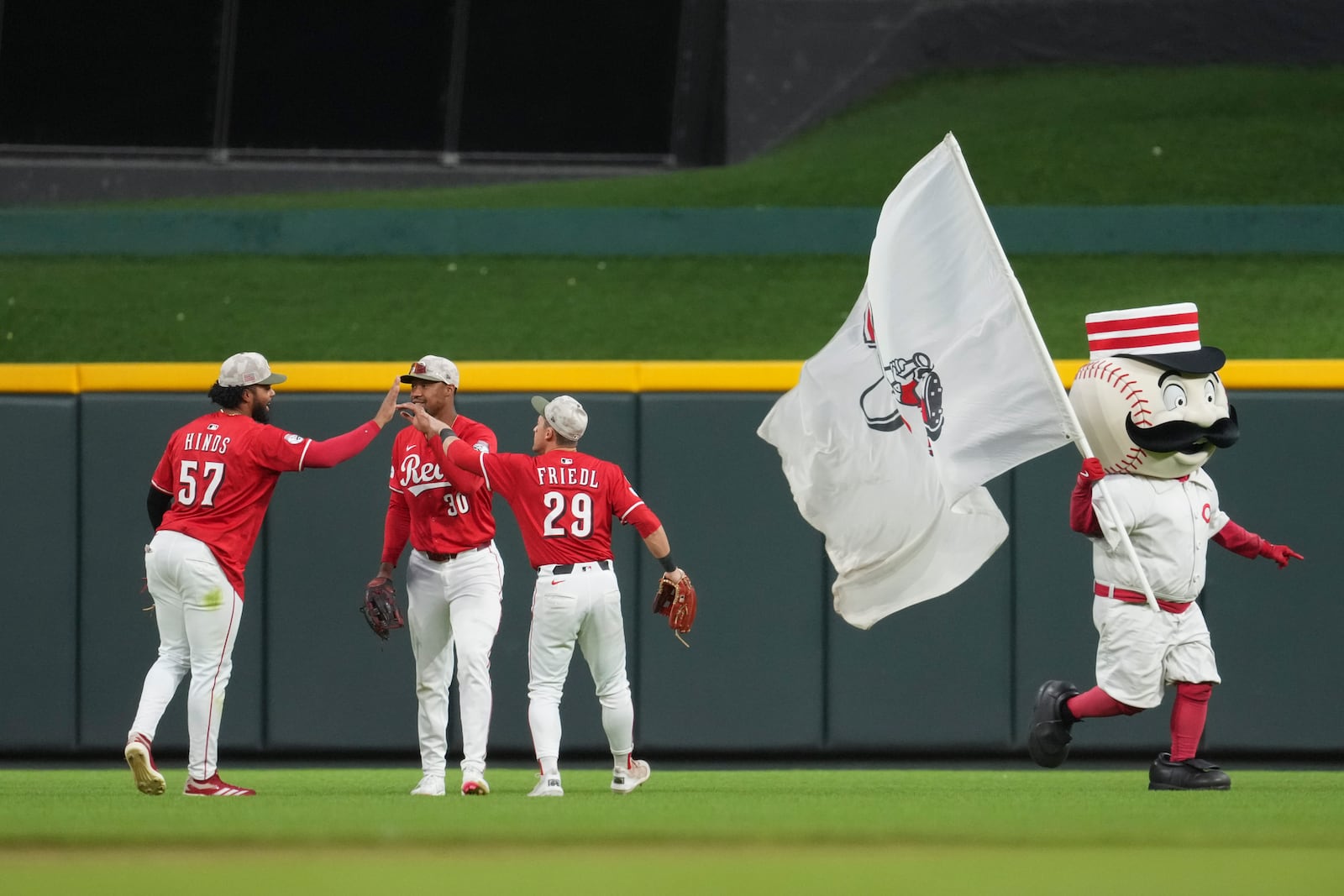 Cincinnati Reds' Rece Hinds (57) celebrates with teammates Will Benson (30) and TJ Friedl (29) following a baseball game against the Cleveland Guardians, Saturday, May 17, 2025, in Cincinnati. (AP Photo/Jeff Dean)