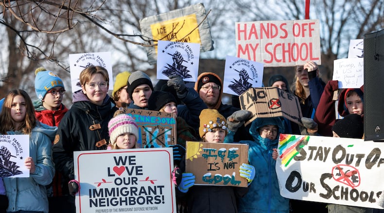 Minneapolis Public Schools families, educators and students hold signs during a news conference at Lake Hiawatha Park in Minneapolis, on Friday, Jan. 9, 2026, demanding Immigration and Customs Enforcement be kept out of schools and Minnesota following the killing of 37-year-old mother Renee Good by federal agents earlier on Wednesday. (Kerem Yücel/Minnesota Public Radio via AP)