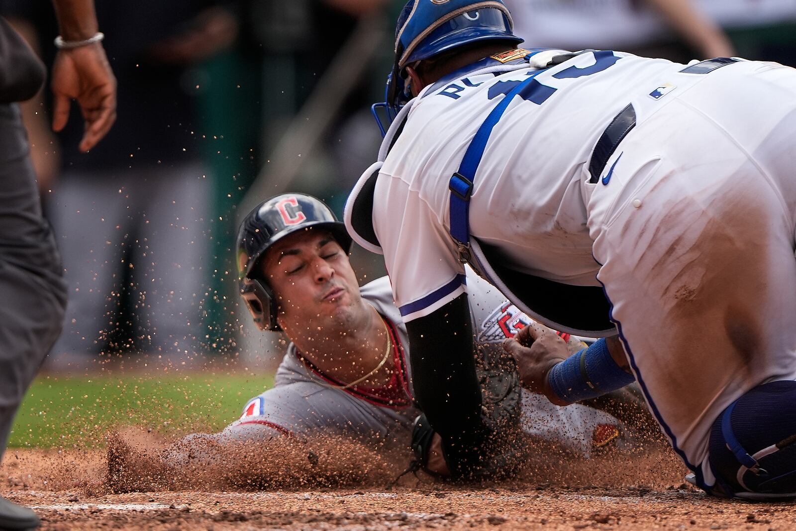 Cleveland Guardians' Brayan Rocchio, left, is tagged out at home by Kansas City Royals catcher Salvador Perez (13) as he tried to score on an RBI double by Bo Naylor during the seventh inning in the first baseball game of a doubleheader, Saturday, July 26, 2025, in Kansas City, Mo. (AP Photo/Charlie Riedel)