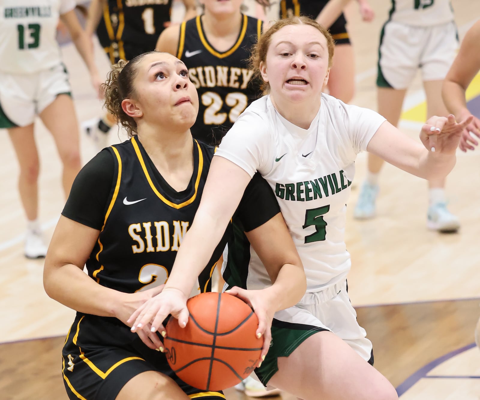Sidney junior forward Olivia Foy shoots with pressure from Greenville's Halle Fourman during a Division III district quarterfinal on Friday, Feb. 20 at Springfield High School. Foy led the Yellow Jackets with 14 points in a 37-24 victory. BRYANT BILLING / STAFF