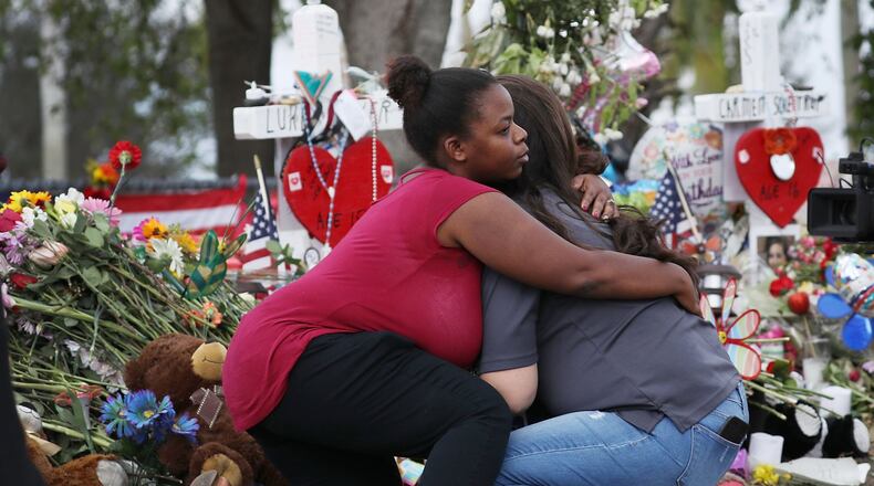 PARKLAND, FL - FEBRUARY 23: Elizabeth Smith (L) and Lindsey Riha both teachers at Marjory Stoneman Douglas High School hug each other as teachers and staff are allowed to return to the school for the first time since the mass shooting on campus on February 23, 2018 in Parkland, Florida. Police arrested 19-year-old former student Nikolas Cruz for killing 17 people at the high school. (Photo by Joe Raedle/Getty Images)
