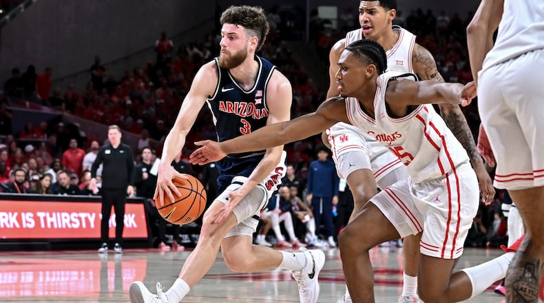 Arizona guard Anthony Dell'orso (3) controls the ball as Houston guard Mercy Miller (25) defends during the first half of an NCAA college basketball game, Saturday, Feb. 21, 2026, in Houston. (AP Photo/Maria Lysaker)