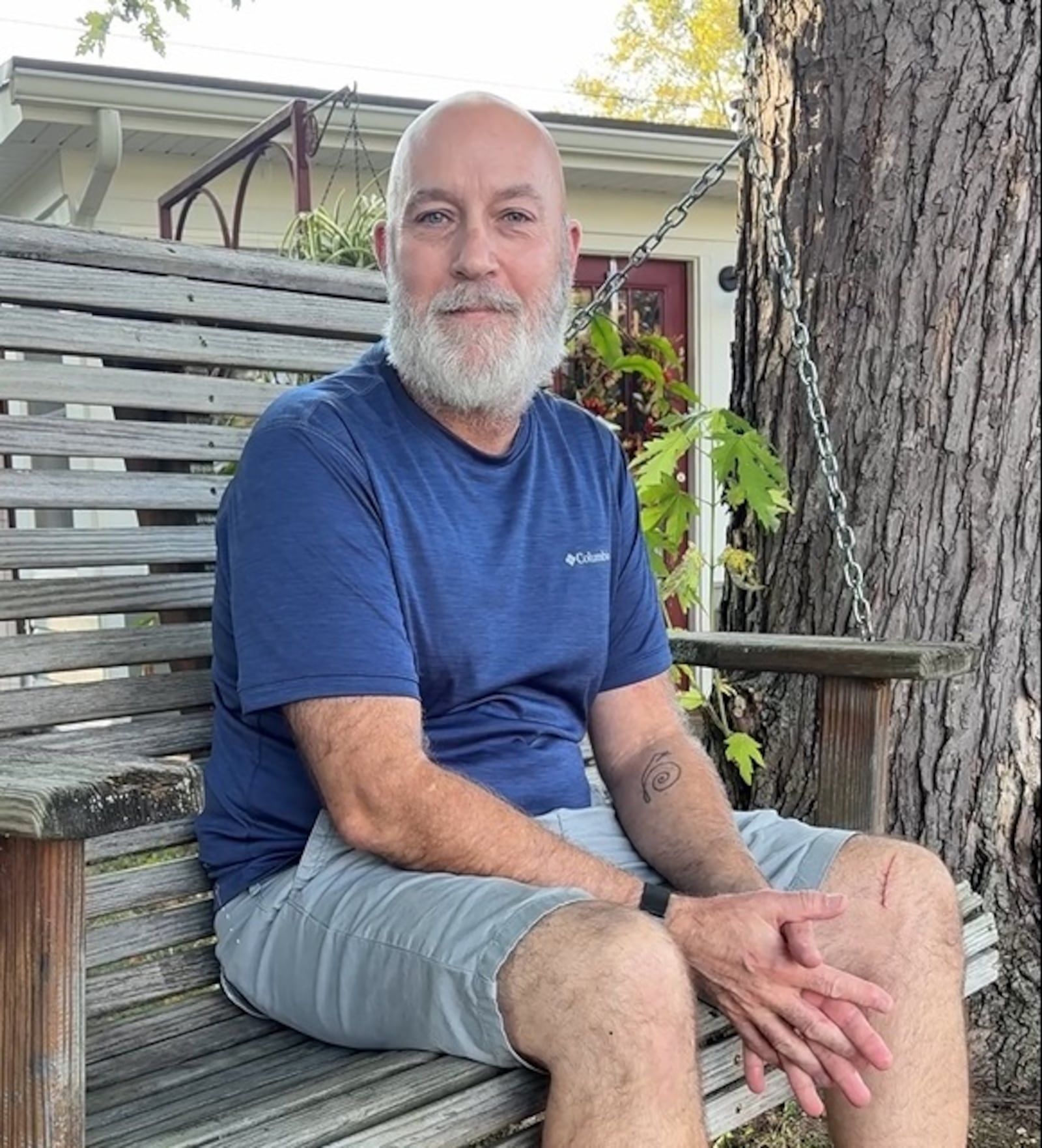 Bill Trent sits on a swing in the front yard of his Courtland Avenue house in Kettering, which received new windows, siding, garage doors and gutters through a lead abatement program in addition to a roof and HVAC system through other rehabilitation programs available to homeowners. JEN BALDUF/STAFF