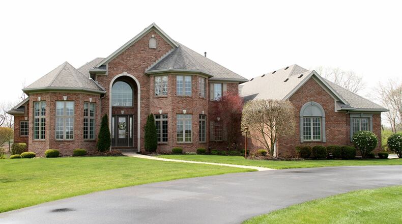 The brick home with turrets and four-car heated garage, sits well off the roadway at 1538 E. U.S. Route 36, just outside Piqua. The three levels have about 8,500 square feet of living space that includes two kitchens, a media room, first-floor main bedroom, study with wood ceiling, formal areas, great room and hearth room. CONTRIBUTED PHOTOS BY KATHY TYLER