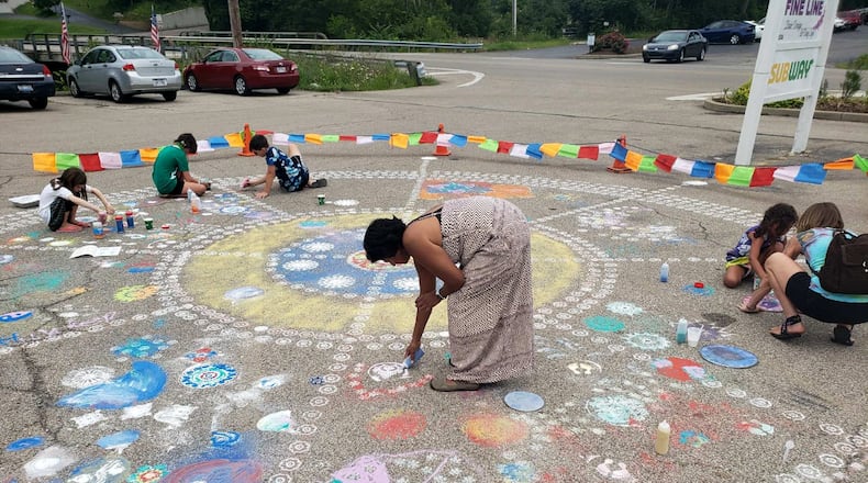 At a recent ArtFest event at Art Town in Bellbrook, an artist from India, Radha Lakshmi, created a chalk 50-foot mandala with the help of local children. JOHN LANDSIEDEL / CONTRIBUTED