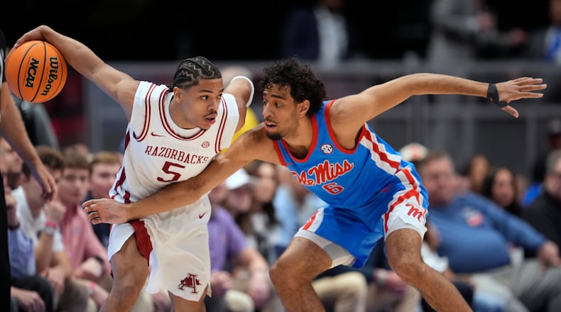 Arkansas guard Darius Acuff Jr. (5) dribbles the ball past Mississippi guard Ilias Kamardine (6) during the first half of an NCAA college basketball game in the semifinals of the Southeastern Conference tournament Saturday, March 14, 2026, in Nashville, Tenn. (AP Photo/George Walker IV)